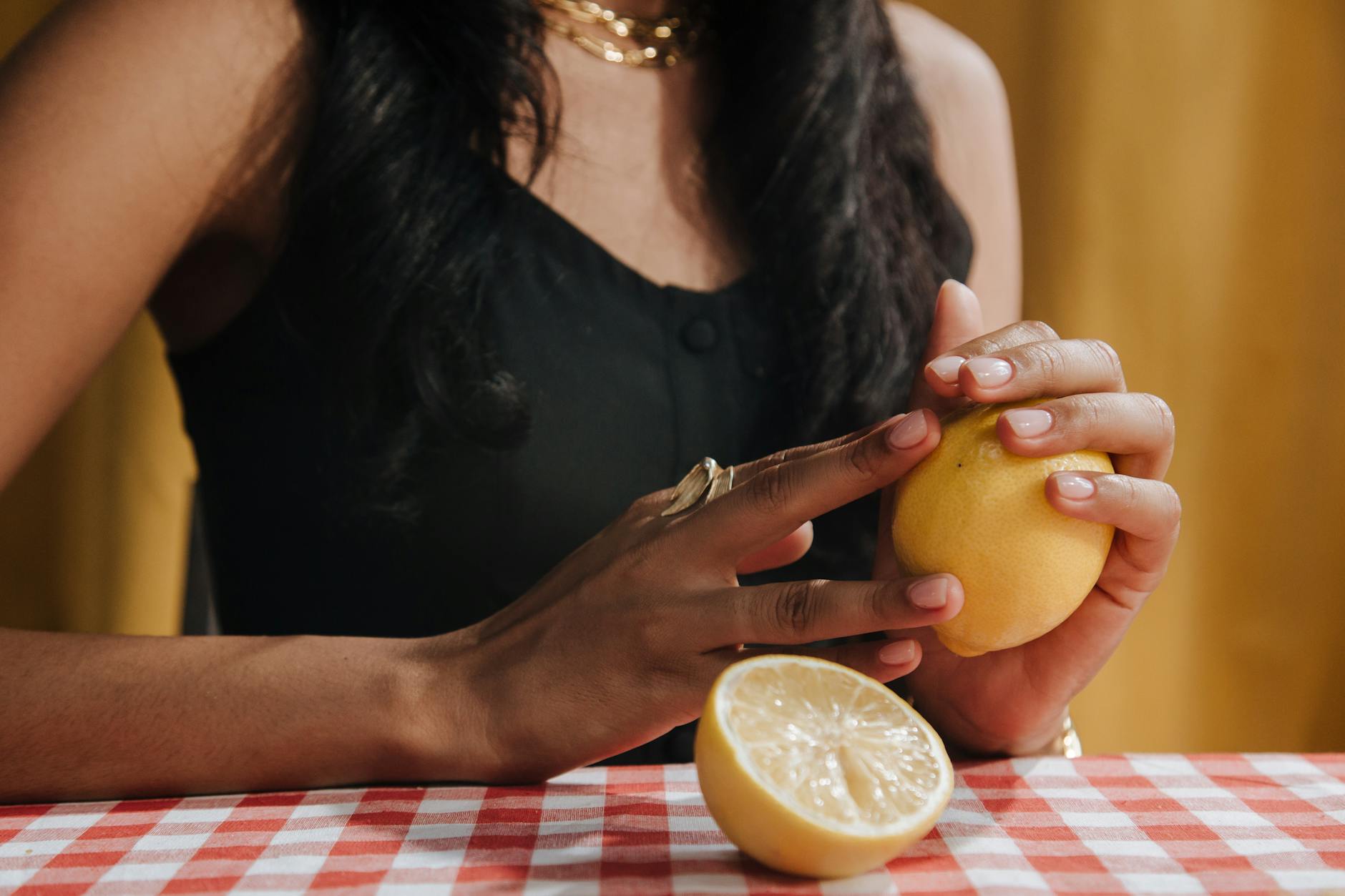 A woman holding a fresh lemon, symbolizing renewal and sensation.