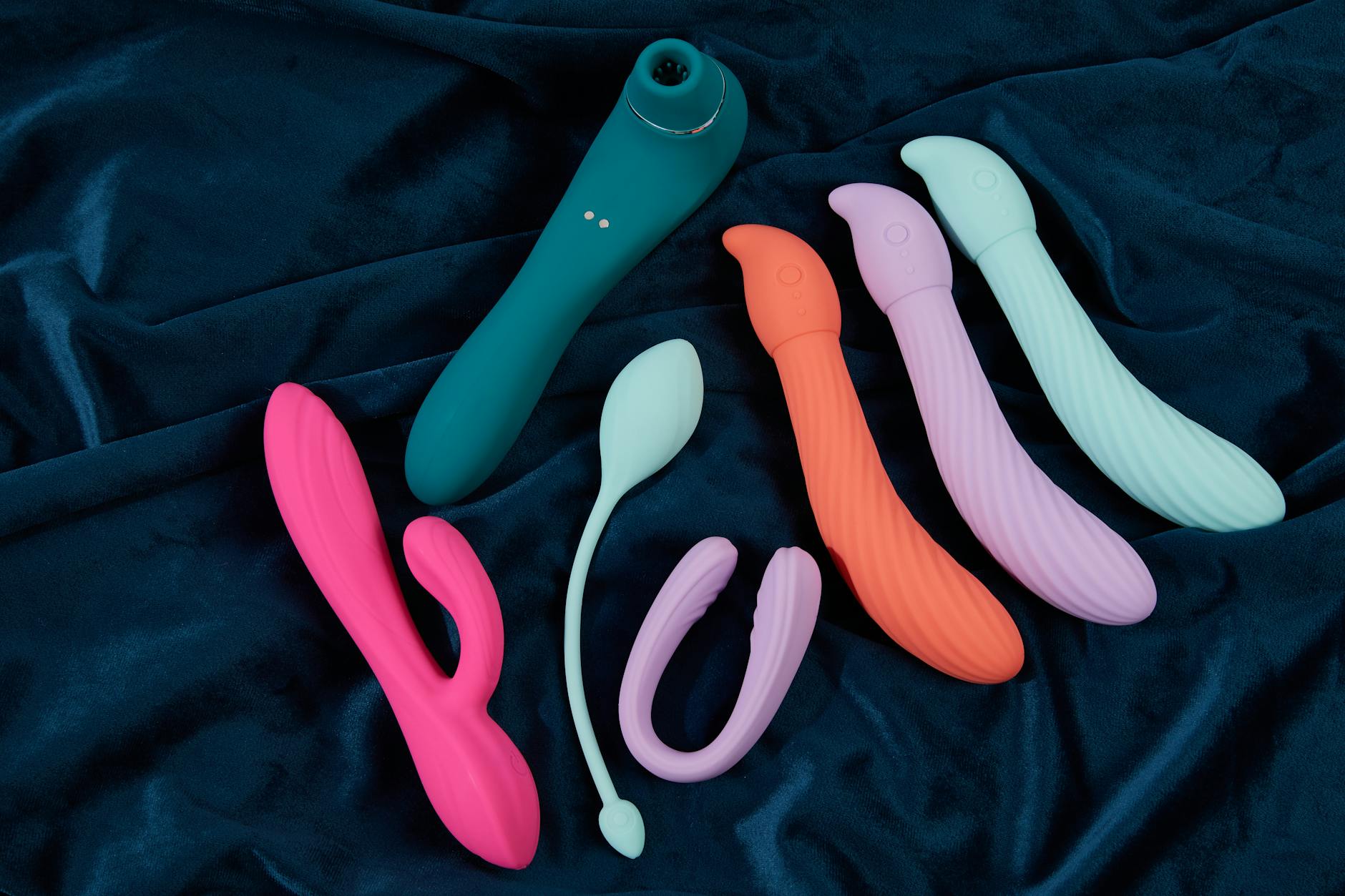 A blue silicone sex toy held in hand against a solid purple background, promoting self-love and sensation