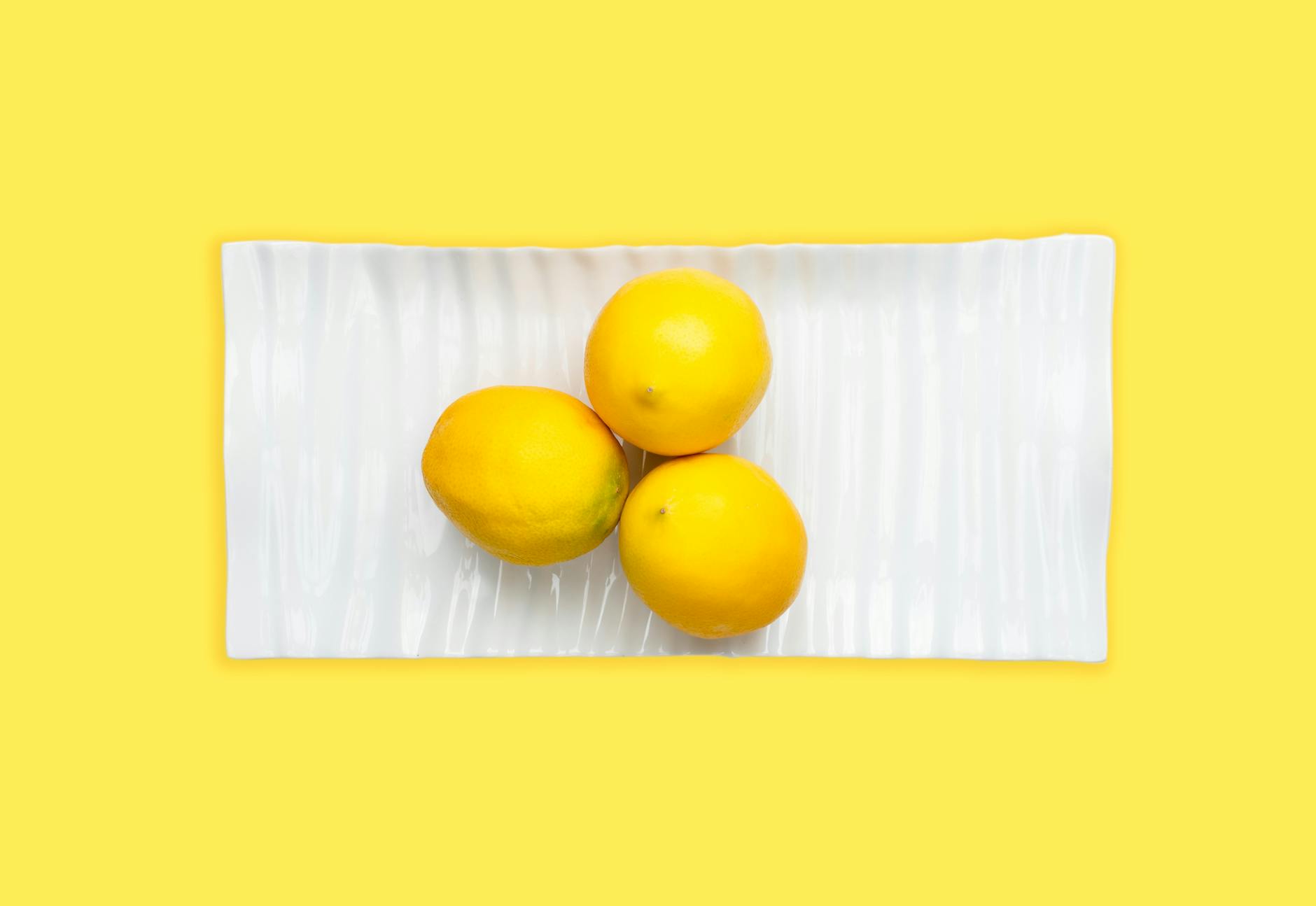 Fresh lemons stacked with books on a white tablecloth, symbolizing clarity and recovery