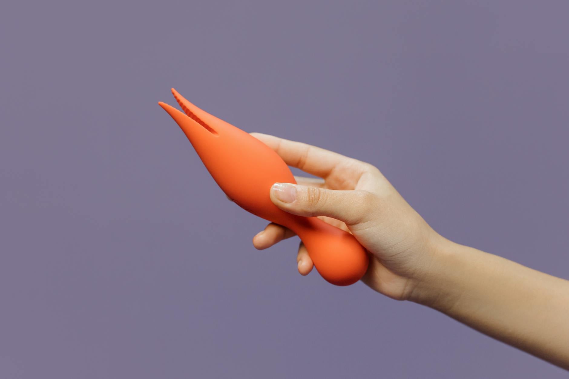Hand holding a lemon clitoral vibrator against a minimalist backdrop, symbolizing sensuality and recovery